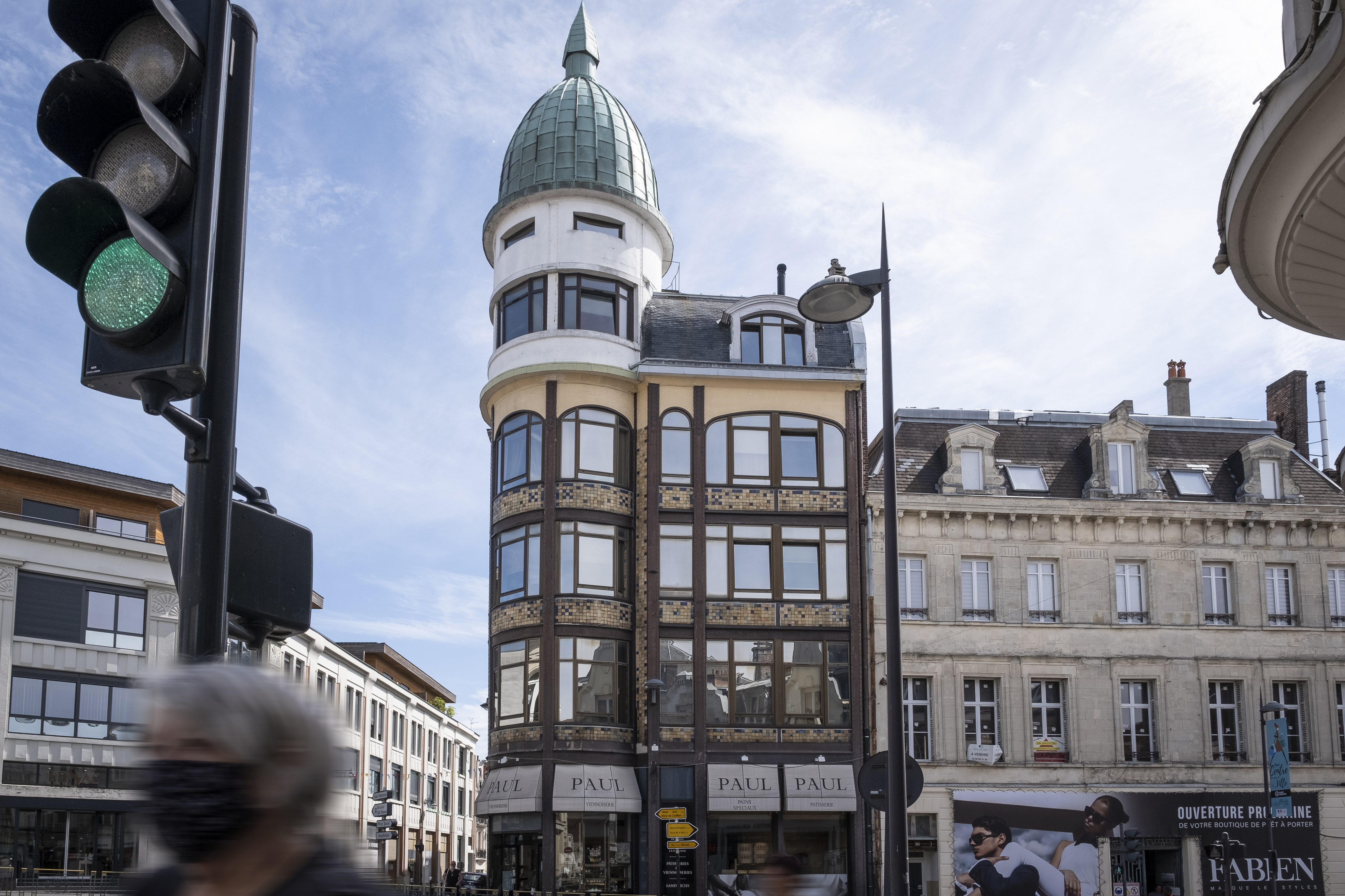 Une vue de rue avec des commerces en pied d'immeuble, en centre-ville de Saint-Quentin dans le Nord.