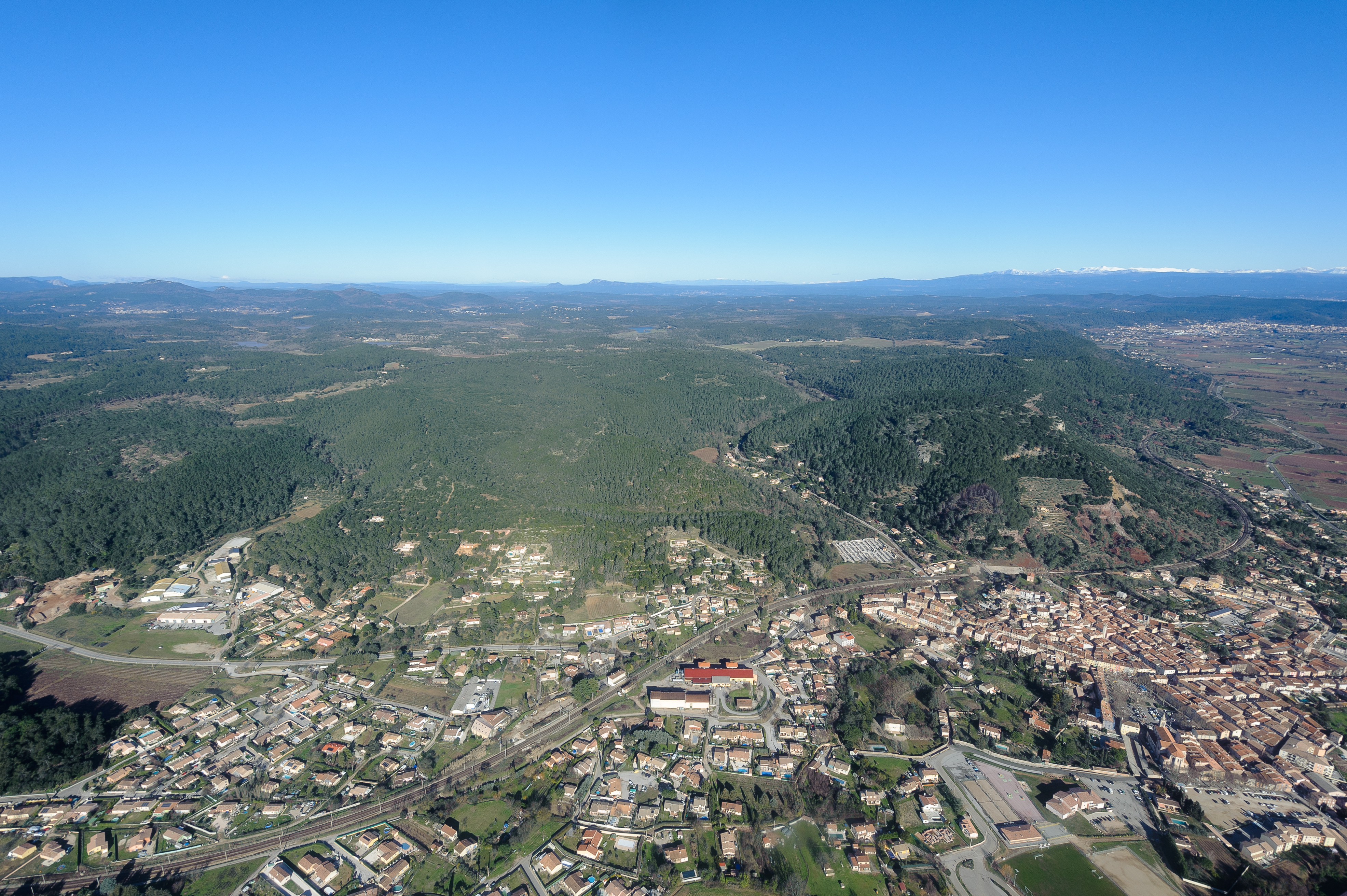 Vue du haut d'un colline d'une petite ville du Gard, avec les collines en arrière-plan