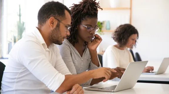 Formateur expliquant le fonctionnement d'un logiciel à une stagiaire