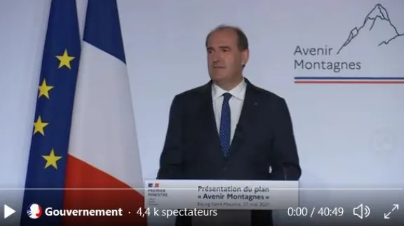 Photo du Premier minstre, au pupitre, pour son discours avec les drapeaux France et UE à côté 