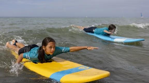 Ados couchés sur des surfs dans l'océan