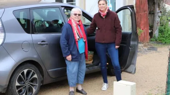 Dame âgée et femme devant une voiture